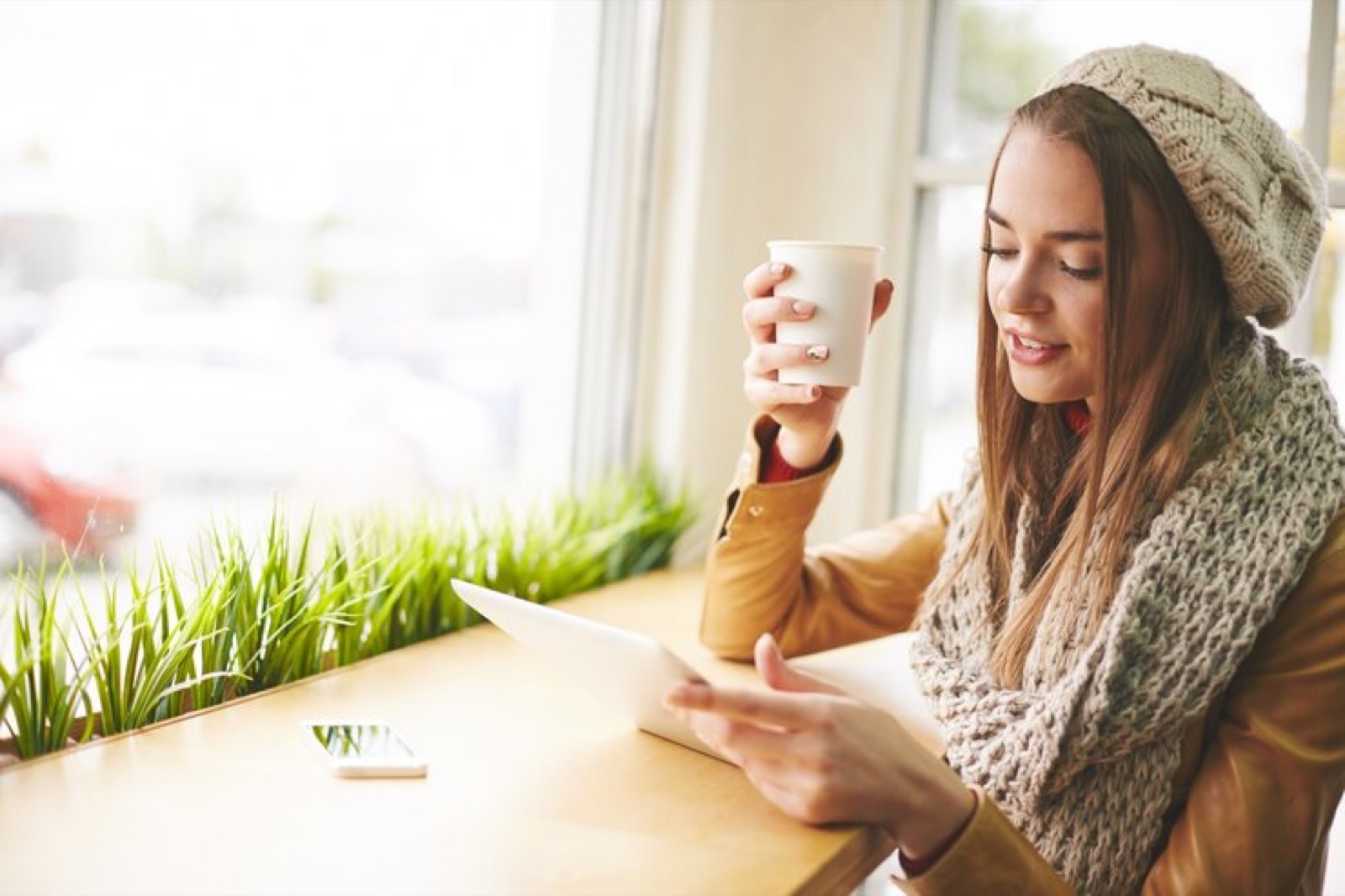 Woman using a tablet at a cafe table