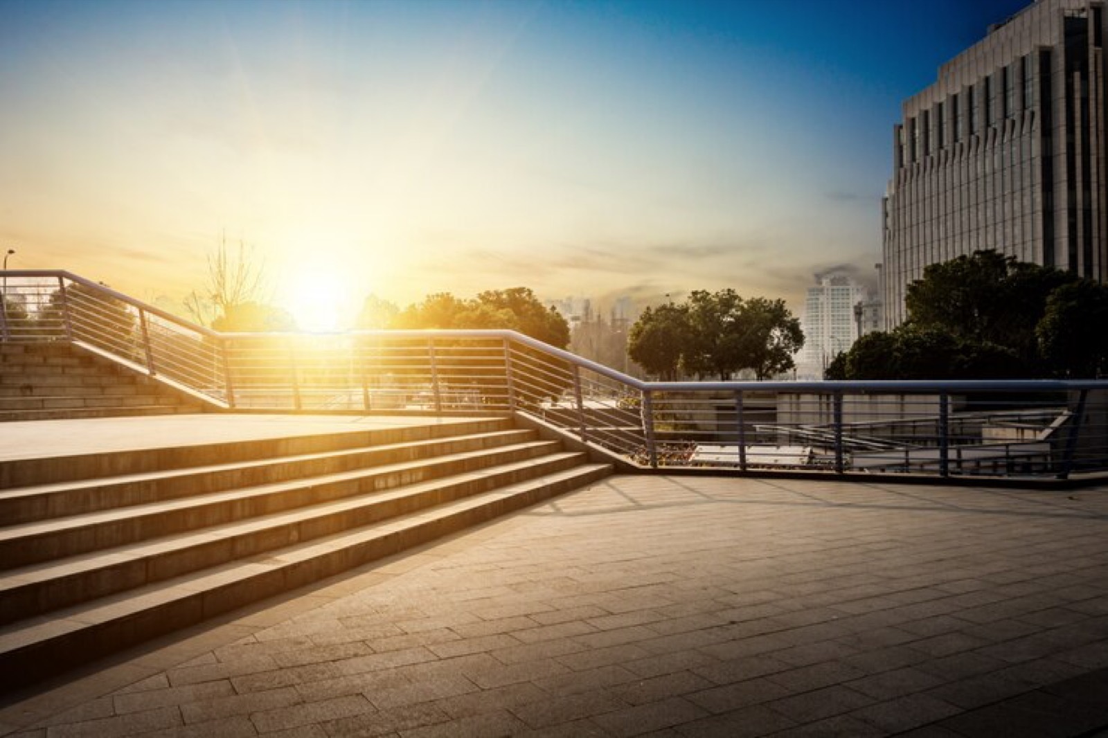 Pedestrian plaza and steps outside city buildings at sunset