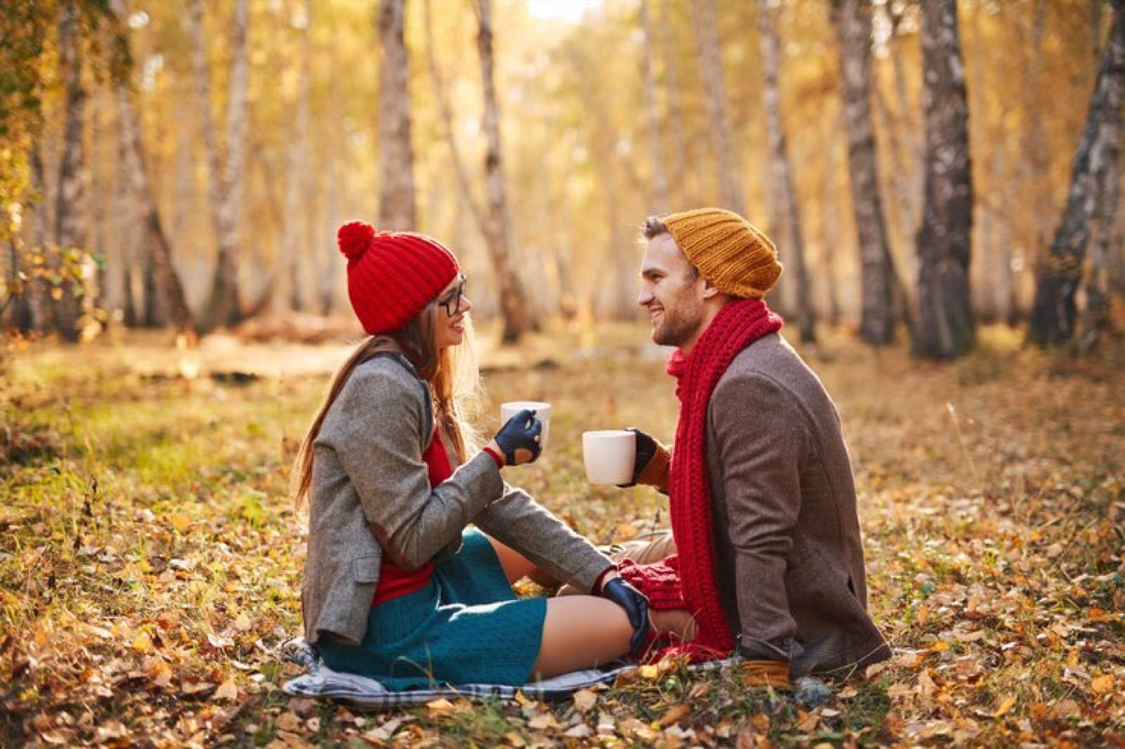 Couple sharing coffee in an autumn forest