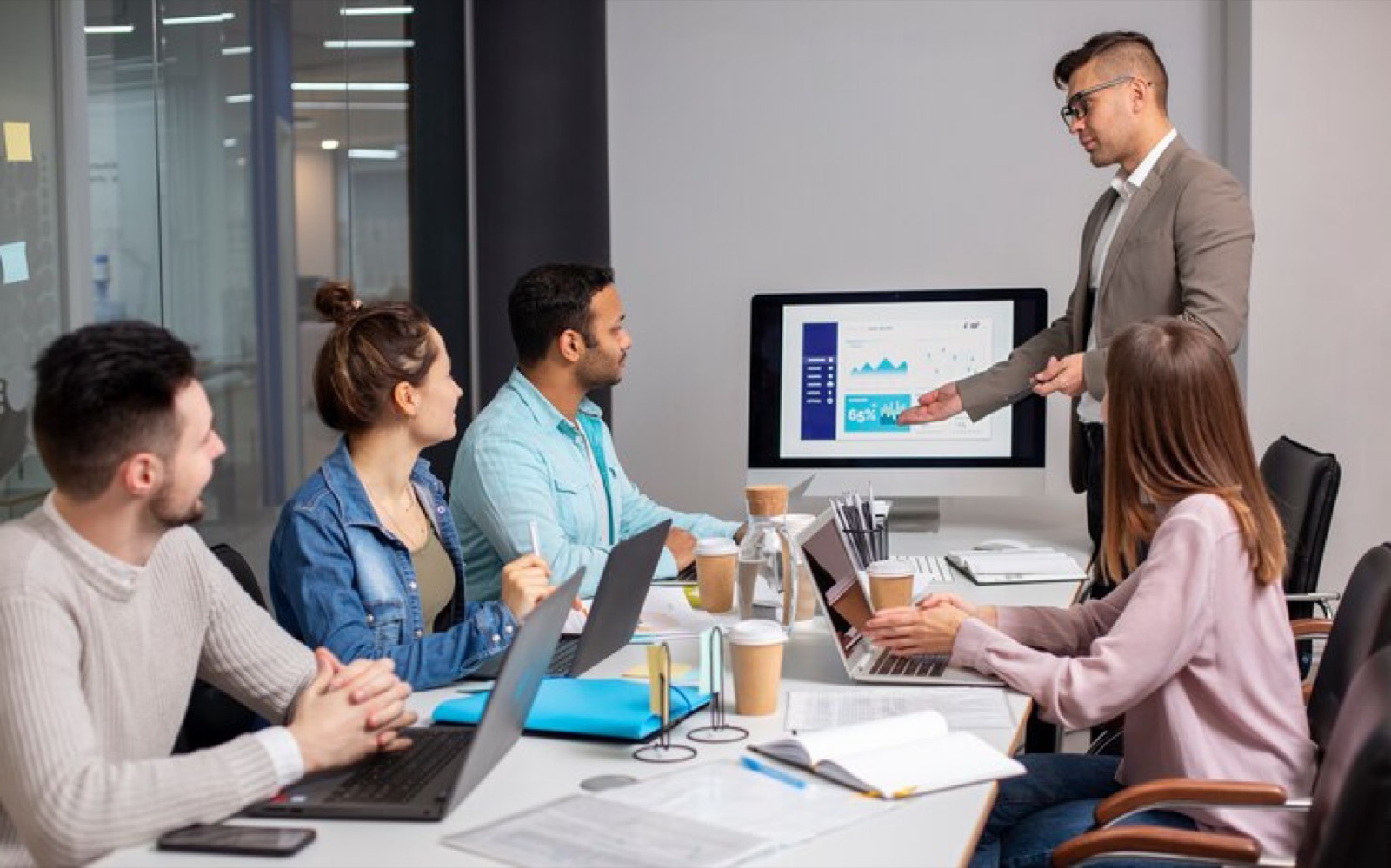 Team reviewing analytics on a screen in a meeting room